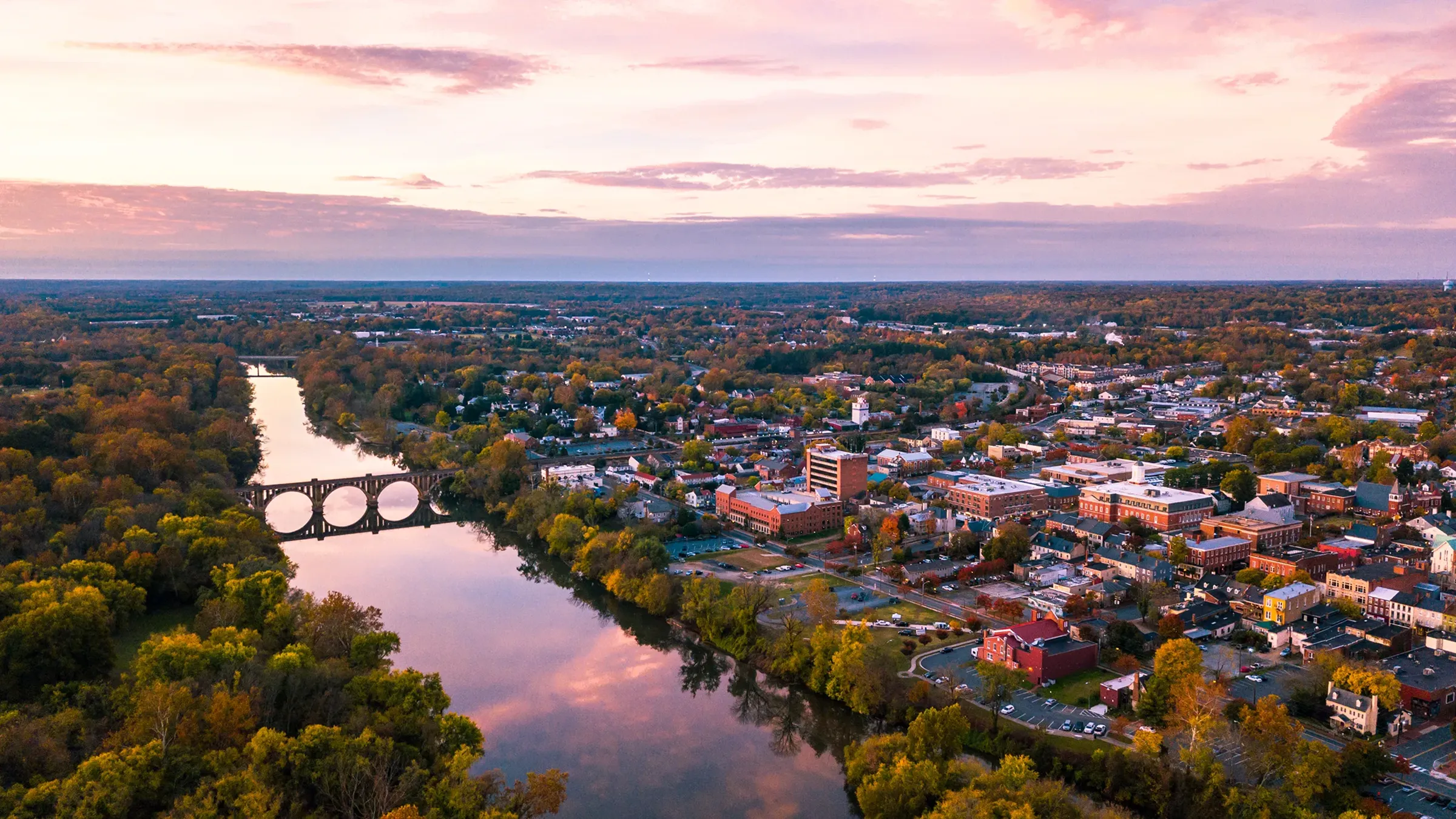 Aerial view of town, river, and arched bridge