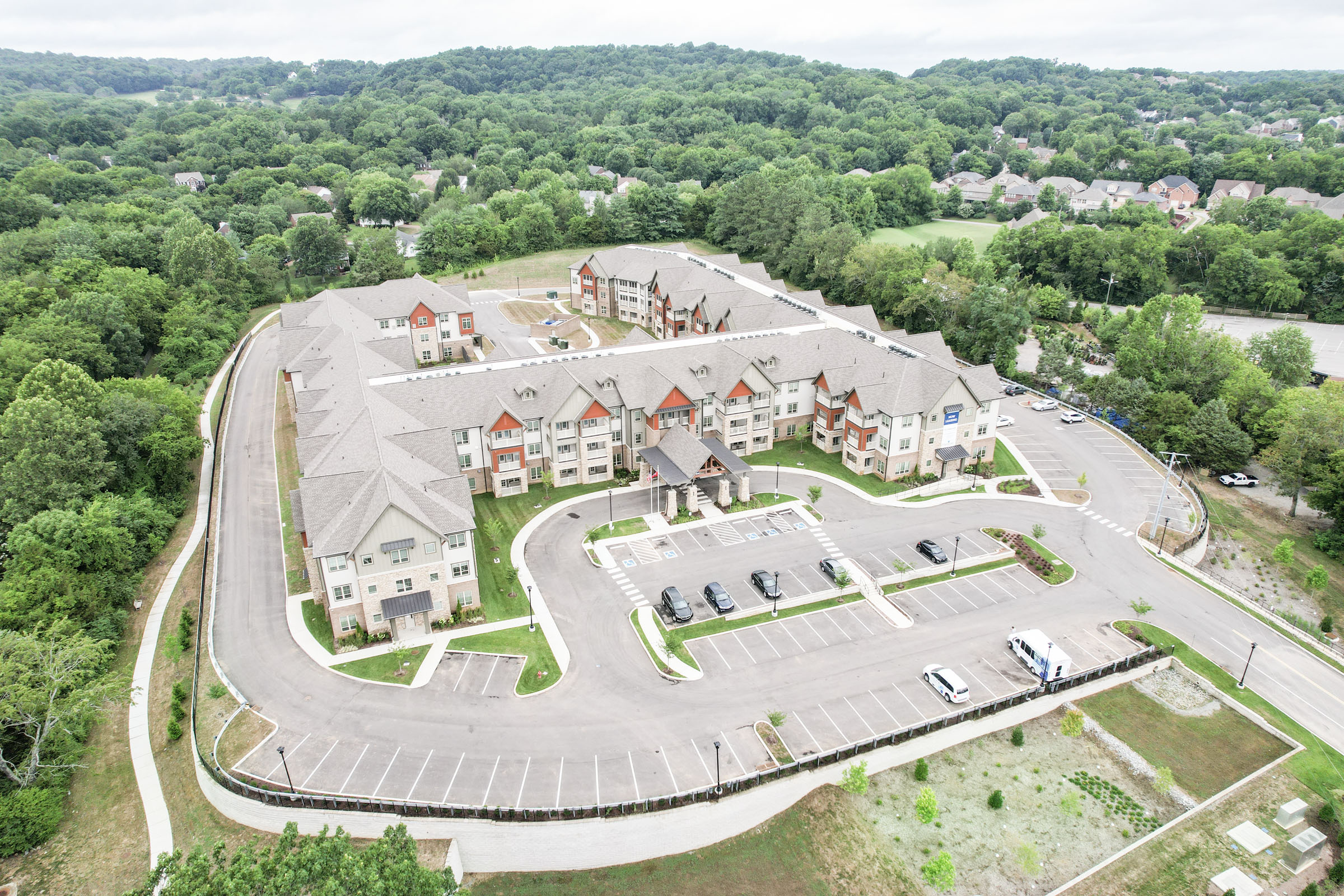 Aerial view of large apartment complex surrounded by trees