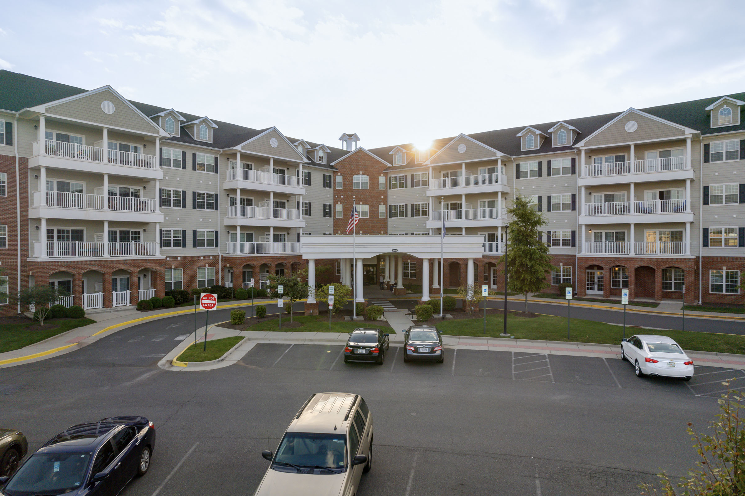 Large apartment building with parking lot at sunset