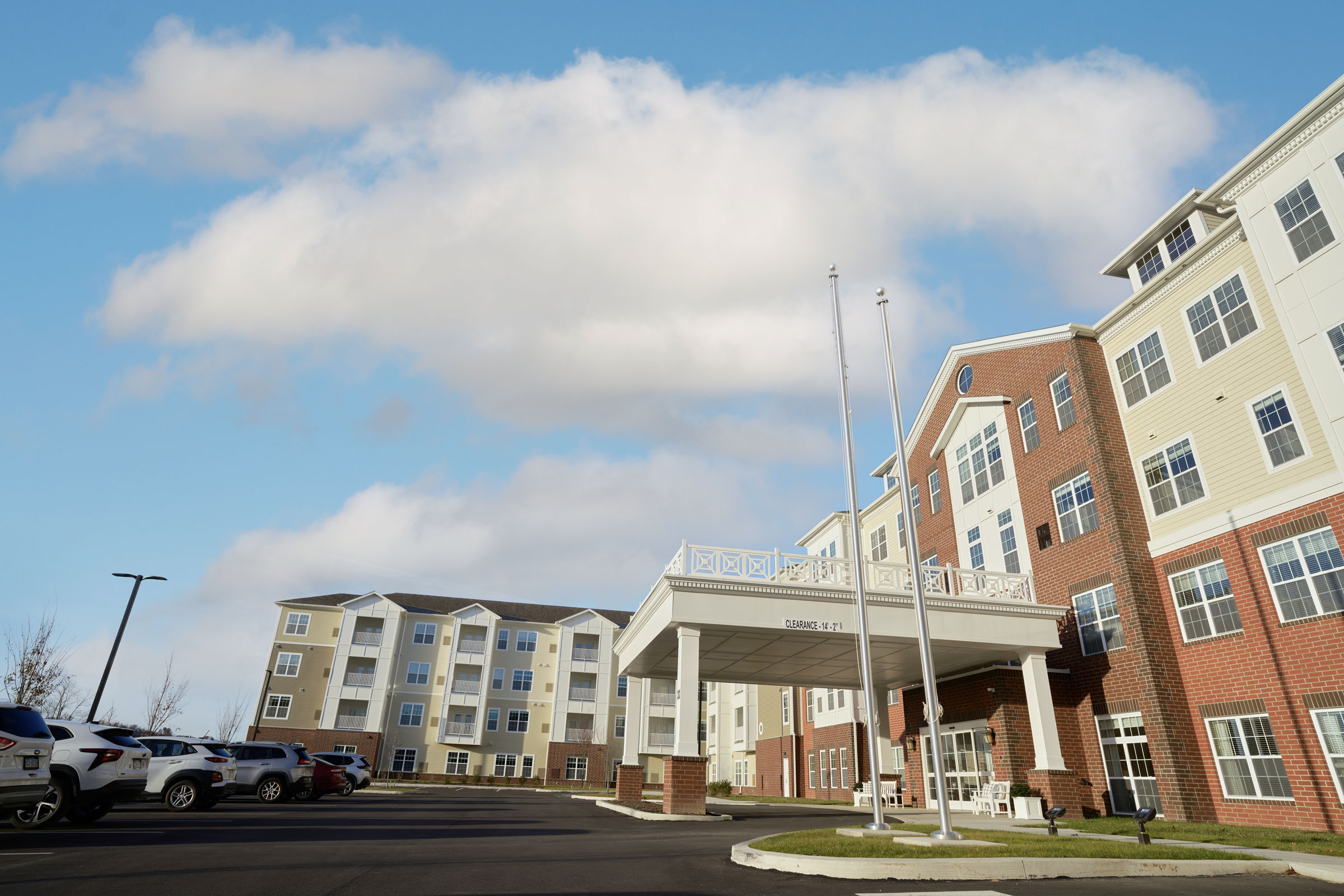 Modern apartment complex with covered entrance and parking